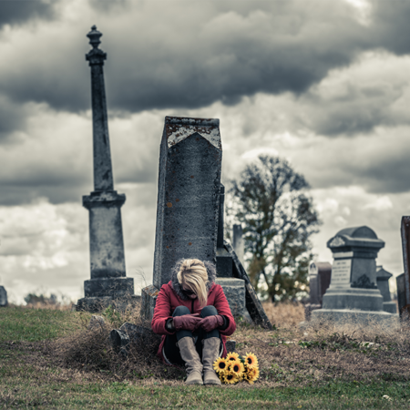 lonely-sad-young-woman-in-mourning-in-front-of-a-g-P89UZ2Z