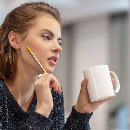 thoughtful-young-woman-making-notes-using-notepad--ABRV67C